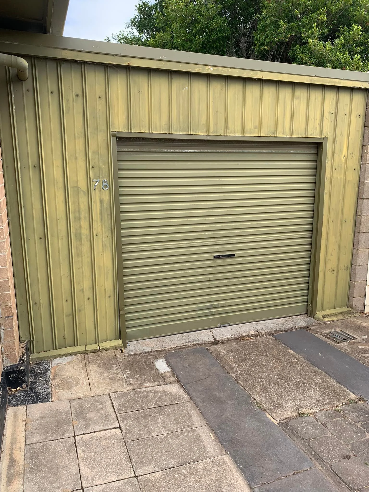 Garage door and steel wall repainted charcoal, before